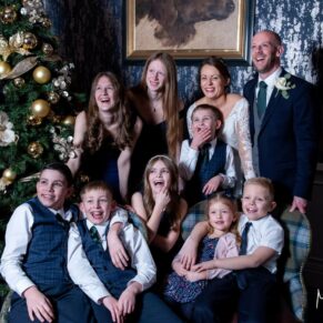 Very relaxed photography pose taken during the drinks reception next to the Christmas tree at this Castle Hotel wedding in Windsor