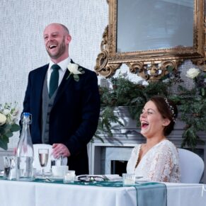 Photography of the bride giggling away during her husband's speech at their Castle Hotel wedding in Windsor