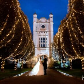 The newlyweds dramatically captured at dusk on the illuminated driveway to Danesfield House on their wedding day