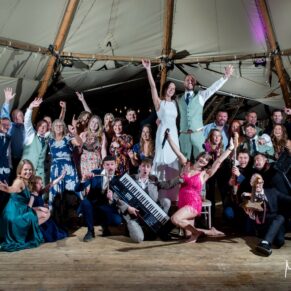 Dovecote Events tipi wedding group pose with the band at the end of a lively evening of dancing