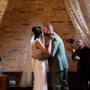 The first kiss during the ceremony inside the rustic barn