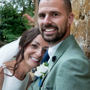 The bride snuggles up to her husband for this lovely relaxed pose outside the barn