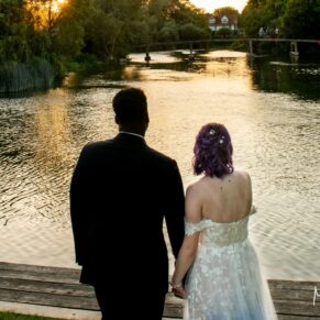 The newlyweds watch the sun setting over the River Thames during their summer wedding at The Great House in Sonning