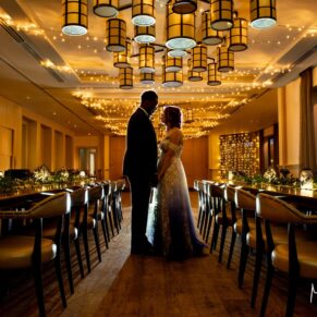 When dusk arrives, I love to bring out my floodlighting for some dramatic poses of the newlyweds. For this silhouette pose captured in the dining room at their Sonning venue, I placed the newlyweds under the striking ceiling lights for the additional wow impact. I'm using multiple lights here to achieve this striking effect, whilst the ceiling fairy lights add a little extra magic. The wow interiors used to maximum effect for this pose with the newlyweds at their Great House in Sonning wedding