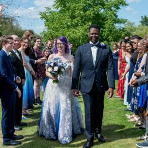 The newlyweds are showered in confetti by their wedding guests after the wedding ceremony at The Great House in Sonning