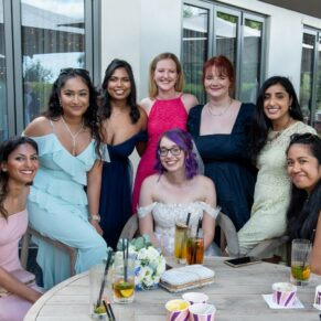 The ladies all gather for this relaxed wedding group pose with the bride under a parasol at the The Great House in Sonning