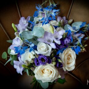 The bride's stunning blue and white bouquet placed onto a leather chair at her Great House wedding in Sonning