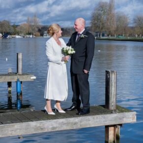 The bride and groom stroll along the jetty by the River Thames in the town centre before their wedding reception