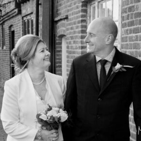 The bride and groom having a giggle as they stroll in the town centre before their wedding reception