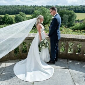 The breeze takes hold of the bride's veil for a fleeting moment on the outdoor terrace during her Latimer Estate wedding