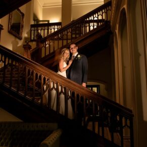 The Latimer Estate staircase dramatically floodlit at night-time with the smiling newlyweds positioned in the foreground for this wedding day photography opportunity