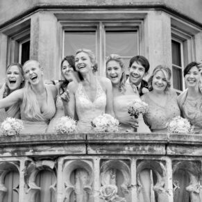 Photography of the groom enjoying a giggle with the ladies who are surrounding him on the terrace at his Latimer Estate wedding