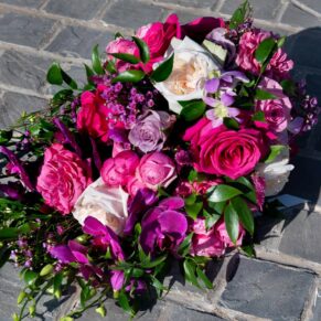 The bride's colourful wedding bouquet captured on the cobblestones at Rackleys Barn