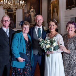 The newlyweds captured in a formal pose with their parents after the civil ceremony