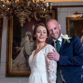 The newlyweds surrounded by opulent portraits of Royalty after their civil ceremony