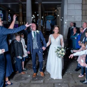 The newlyweds walk through their night time confetti aisle at The Guildhall