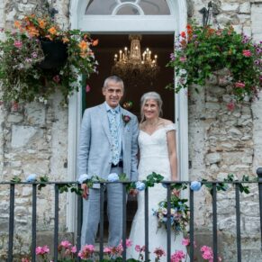 Photography of the bride and groom as they strike a pose by the back entrance of Bisham Abbey during their wedding drinks reception