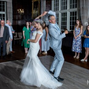 An energetic dance move from the newlyweds during their Bisham Abbey evening wedding reception