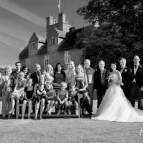 Photography of large family group pose on the lawns during this Bisham Abbey summer wedding reception