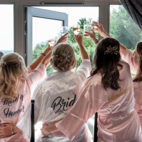 The ladies charge their champagne glasses prior to the wedding ceremony at Cotswolds Hotel, Golf and Spa