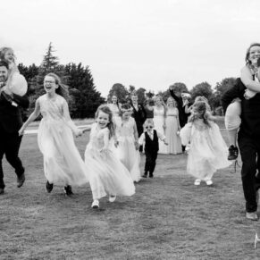 Photography of some children running at full speed towards the camera at this Cotswolds Hotel, Golf and Spa Hotel wedding