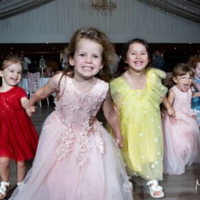 Photography of giggling kids running on the dance-floor at this Cotswolds Hotel, Golf and Spa wedding reception