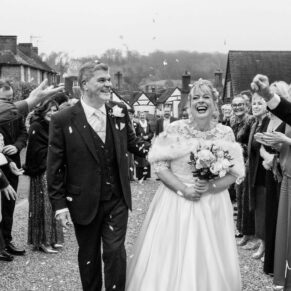 The smiling newlyweds make their way through the confetti aisle at their winter Kings Chapel wedding reception