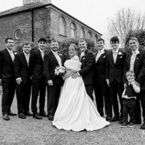 Group pose of the bride and the lads outside the Kings Chapel