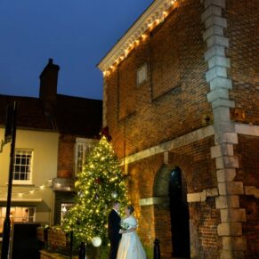The Kings Chapel newlyweds captured beside Old Amersham High Street Market Square after dark on their Christmassy wedding day