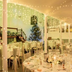 A wide view of a Christmassy wedding breakfast setup inside the Kings Chapel in Old Amersham