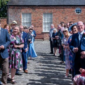 The guest wait in anticipation in the confetti aisle for the newlyweds
