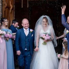 The bride and groom exit the wedding ceremony into the courtyard to a sea of confetti at Meols Hall