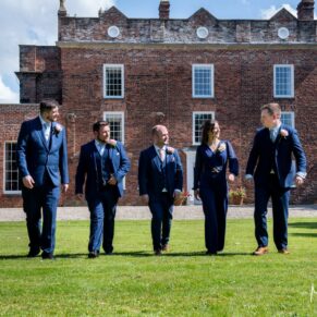 The groom and his ushers take a stroll in front of the main house at Meols Hall