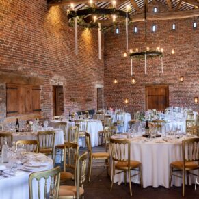 The grand interior of Meols Hall Barn all setup for the wedding breakfast