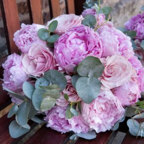 Striking pink bride's bouquet placed on the chair in the sunshine
