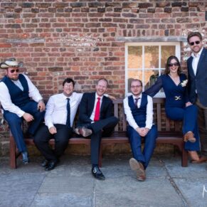 Some of the wedding guests relax on a bench outside Meols Hall