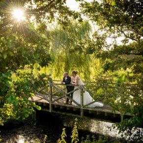 The newlyweds enjoy some solitude on the bridge at their sunny Meols Hall wedding reception