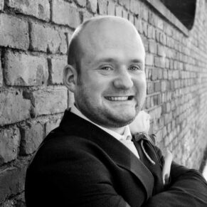 The groom stood against a wall for his portrait prior to the ceremony