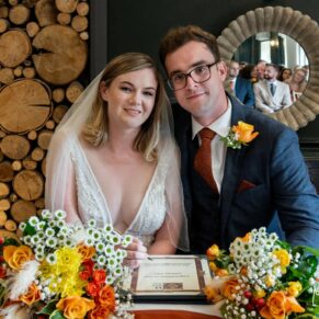 The newlyweds pose for the camera during the signing of the register