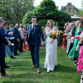 The newlyweds navigate the confetti aisle during their drinks reception