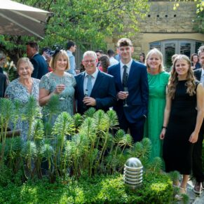 A family wedding group pose captured in the grounds of The Manor House Hotel in Moreton-in-Marsh