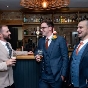 The groom and the lads enjoy a little banter in the bar prior to the civil ceremony at The Manor House Hotel in Moreton-in-Marsh