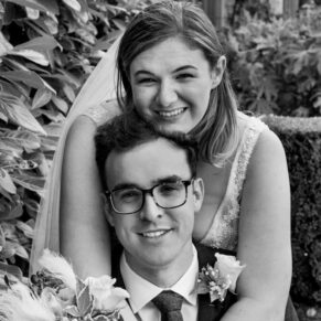 The bride gives her husband a bear hug during the garden drinks reception