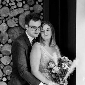 The bride and groom snuggle up for a romantic pose Manor House Hotel Moreton-in-Marsh