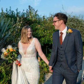 The bride and groom take a stroll in the gardens of the hotel during their summer wedding reception