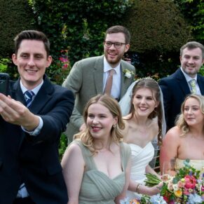 Group poses can be as relaxed as you like, this selfie shot was captured during the wedding drinks reception at Chenies Manor