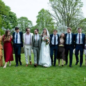 Group poses can be as relaxed and informal as you like throughout your wedding day. This capture from Chenies Manor showcases how much fun the pictures can be. and bringing motion into the imagery can really lift your wedding photography to another level on the day. The laughter and smiles really make this type of image jump from the screen! This shot of the newlyweds with their friends was one of my favourites from this spring wedding in Buckinghamshire A relaxed walking photography shot of the bride and groom with their friends captured during the drinks reception at their Chenies Manor spring wedding reception