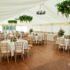 Photography of the striking marquee interior all prepared for the wedding breakfast at Chenies Manor