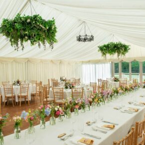 Photography of the marquee interior all setup for the wedding breakfast at Chenies Manor
