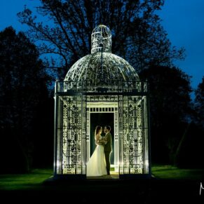 Once the light fades I love to bring out my floodlights to sprinkle a little magic! And at Chenies Manor the backdrops and photographic opportunities are off the scale after dark. In this shot I've backlit the bride and groom and rose arbour to create a fabulous grand finale for their wedding photographs. I visited several locations with the newlyweds after sundown to capture various vistas and use different dramatic lighting effects. Dramatic dusk portrait of the bride and groom under the wrought iron rose arbour at their Chenies Manor wedding